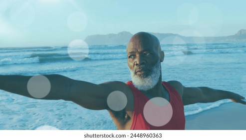 Image of senior african american man practicing yoga at beach over light spots. leisure and wellbeing conacept digitally generated image. - Powered by Shutterstock