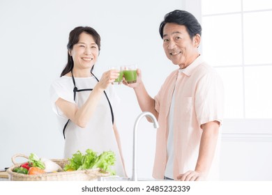 Image of senior citizen in kitchen with health-conscious green juice (drink) Close-up looking at camera - Powered by Shutterstock