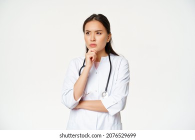 Image Of Serious Doctor, Female Healthcare Worker Thinking, Looking Aside With Concerned, Frowning Face Expression, White Background