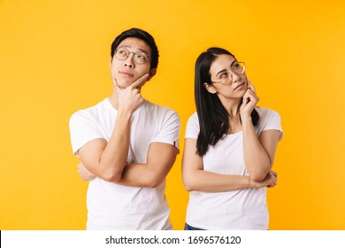 Image Of Serious Multinational Man And Woman Thinking And Looking Aside Isolated Over Yellow Background