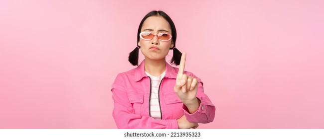 Image Of Serious, Stylish Asian Girl In Sunglasses, Showing Stop, Prohibit Gesture, Taboo Sign, Saying No, Standing Over Pink Background