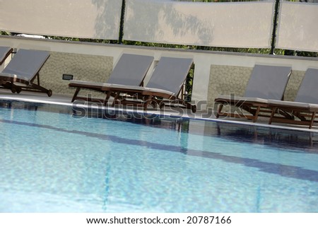 an image of several deck-chairs by the pool