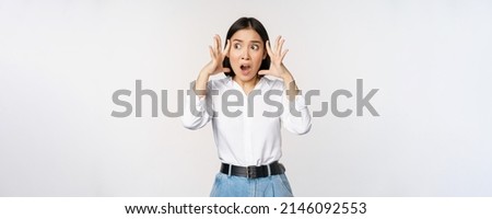 Image of shocked anxious asian woman in panic, holding hands on head and worrying, standing frustrated and scared against white background