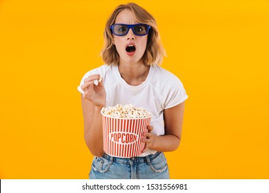 Image Of Shocked Blond Woman In 3D Glasses Holding Popcorn Bucket While Watching Movie Isolated Over Yellow Background