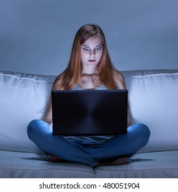 Image of shocked girl using facebook at night