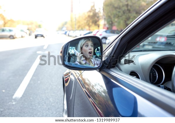 Image of a shocked woman in the side view mirror,
risky driving