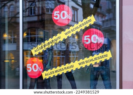 An image of a shop window with german text Everything has to go, we're closing and 50 percent sign