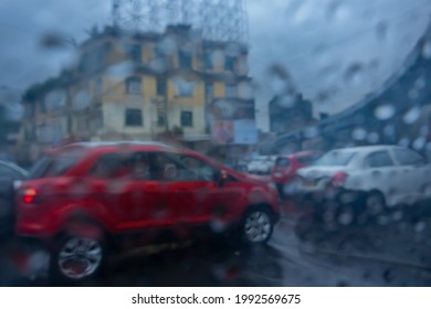 Image shot through raindrops falling on wet glass, abstract blurs of traffic - monsoon stock image of Kolkata (formerly Calcutta) city ,