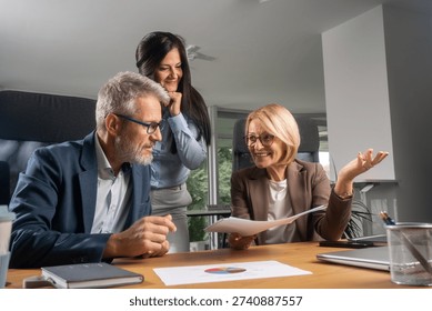 The image showcases professionals engaged in a collaborative meeting, highlighting teamwork, communication, and a productive office environment, captured within a contemporary workspace.