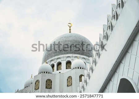 Image showcasing a beautiful Sheikh Zayed Grand Mosque with intricate architecture, featuring golden details and a stunning dome, set against a soft cloudy sky, evoking tranquility and spirituality