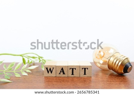An image showing power consumption using a light bulb and the word WATT.
