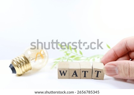 An image showing power consumption using a light bulb and the word WATT.