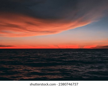 
The image shows a beautiful sunset over the ocean. The sky is ablaze with color, from deep orange and red to fiery yellow and pink. The sun is setting low in the sky. - Powered by Shutterstock