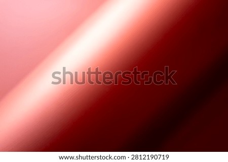 The image shows a close-up, abstract view of flowing red fabric. The fabric has a smooth, satiny texture with dramatic lighting that creates highlights and shadows.