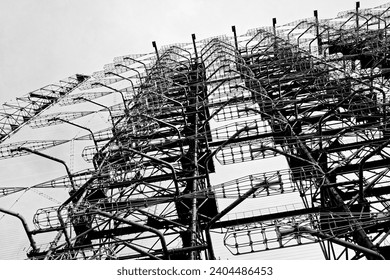 The image shows a complex structure of metal scaffolding and wiring against a clear sky, appearing intricate and abandoned. Duga is a Soviet radar station for detection system for ICBM launches.