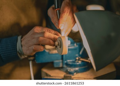 The image shows a Cremona violin maker carving a pegbox with a chisel under lamplight. His skilled hands, blue vise, classic toolset and wooden scroll evoke the artistry of Italian tradition.