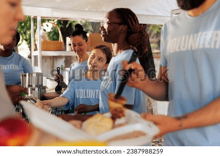 Image shows essence of support, giving, and volunteering as charity workers share warm meals and non-perishables with underprivileged. Voluntary individuals assist needy and homeless people.