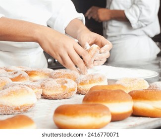 The image shows a person making donuts indoors.