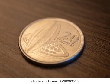The image shows the reverse (front) view of a 20 Pesewas coin from Ghana. It features two cocoa pods (fruits), representing Ghana's status as a major world producer, alongside the numeral 20 and the word PESEWAS.