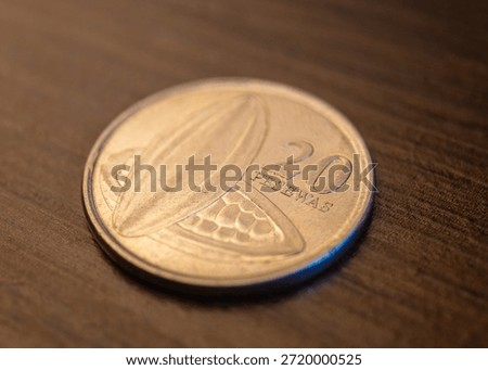 The image shows the reverse (front) view of a 20 Pesewas coin from Ghana. It features two cocoa pods (fruits), representing Ghana's status as a major world producer, alongside the numeral 20 and the word PESEWAS.