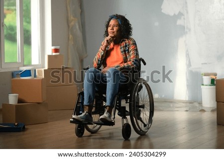 The image shows a room in which renovations are underway, they are not yet finished. In the center of the room sits a woman in a wheelchair. She is scrutinizing the room, contemplating ストックフォト © 