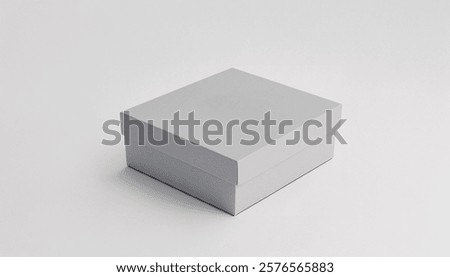 Image shows a simple, closed, square-shaped, light gray cardboard box on a white background. Premium mockup with a clean and elegant white background.