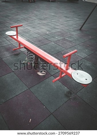 The image shows a spring seesaw, which is a type of playground equipment at Dungun Hospital. Cinematic picture.
