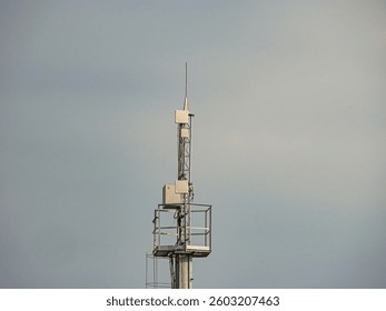 Image shows a tower with multiple structures, possibly communication equipment, on a clear day Tower has platforms for maintenance or access The text USER overlays the image