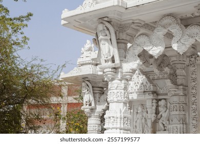 The image shows a white marble temple adorned with intricate carvings and sculptures of deities. The ornate architectural details highlight its cultural and artistic significance. - Powered by Shutterstock