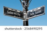 An image with a signpost pointing in two different directions in German. One direction points to I can, the other points to resignation.