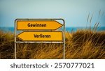 An image with a signpost pointing in two different directions in German. One direction points to win, the other points to lose