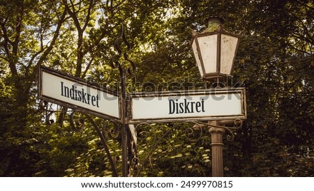An image with a signpost pointing in two different directions in German. One direction points to Discreet, the other points to Indiscreet.