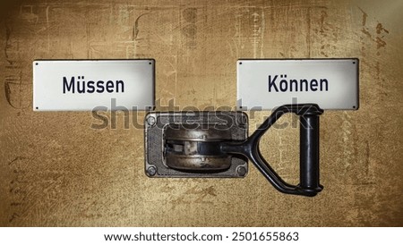 An image with a signpost pointing in two different directions in German. One direction points to ability, the other points to necessity.