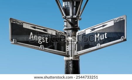 An image with a signpost pointing in two different directions in German. One direction points to courage, the other points to fear.