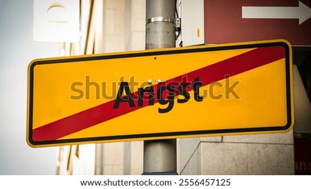 An image with a signpost pointing in two different directions in German. One direction points to courage, the other points to fear.
