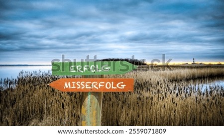 An image with a signpost pointing in two different directions in German. One direction points to success, the other points to failure.