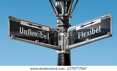 An image with a signpost pointing in two different directions in German. One direction points to Flexible, the other points to Inflexible.