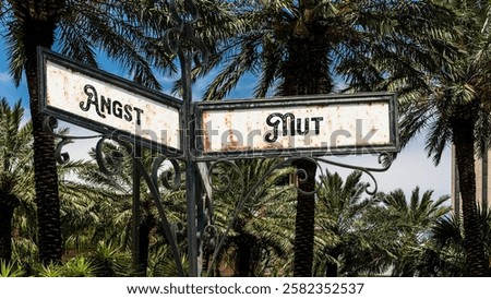 An image with a signpost pointing in two different directions in German. One direction points to courage, the other points to fear.