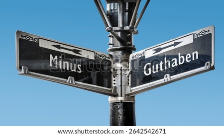 An image with a signpost pointing in two different directions in German. One direction points to credit, the other points to minus.
