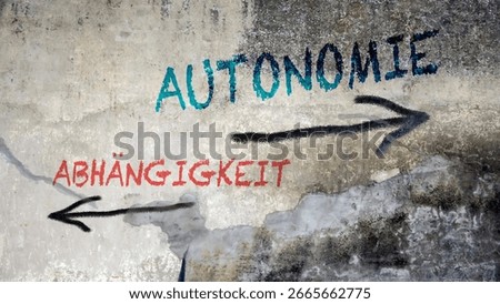 An image with a signpost pointing in two different directions in German. One direction points to autonomy, the other points to dependency.