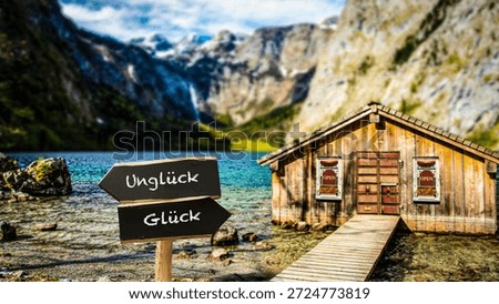 An image with a signpost pointing in two different directions in German. One direction points to happiness, the other points to misfortune.
