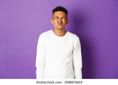 Image Of Silly And Awkward African-american Guy Waiting For Kiss, Standing Nervous With Closed Eyes Over Purple Background