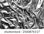 Image of Silver chrome color crumpled aluminum foil close up. Texture for background usage