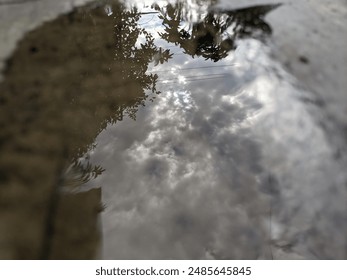 the image of the sky reflected in a puddle of water
