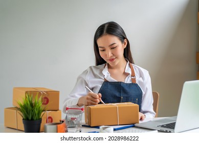 Image Of A Small Business Owner Holding A Pen And A Parcel Box To Write Down The Address For Home Delivery.