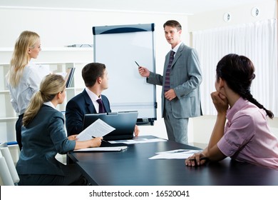 Image Of Smart Business People Looking At Their Leader While He Explaining Something On Whiteboard During Seminar