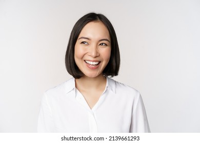 Image Of Smiling Asian Woman Planning, Thinking Of Smth, Daydreaming, Standing Over White Background With Smug Face