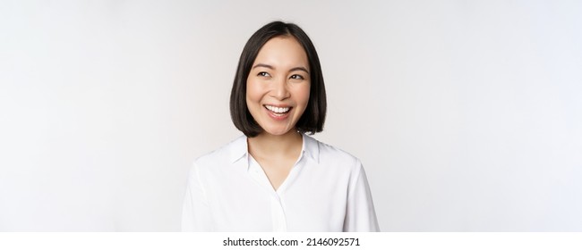 Image Of Smiling Asian Woman Planning, Thinking Of Smth, Daydreaming, Standing Over White Background With Smug Face