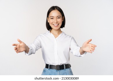 Image Of Smiling Asian Woman Welcoming Guests Clients, Businesswoman Stretching Out Open Hands, Greeting, Standing Over White Background