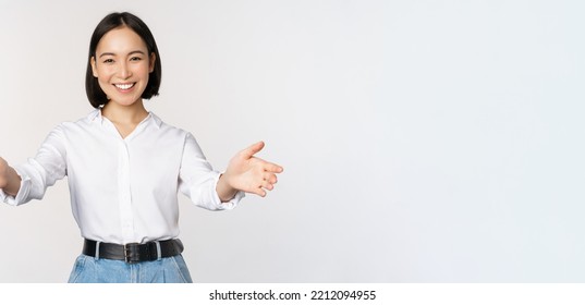 Image Of Smiling Asian Woman Welcoming Guests Clients, Businesswoman Stretching Out Open Hands, Greeting, Standing Over White Background